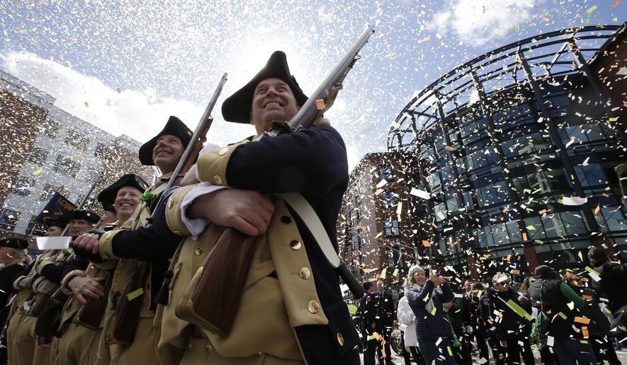 Lexington Minutemen Revolutionary War re-enactors hold their rifles as confetti falls at the start of the annual St. Patrick's Day parade, Sunday, March 17, 2019, in Boston's South Boston neighborhood. The city celebrated the holiday with crowds lining the route of the 118th edition of the parade. (AP Photo/Steven Senne)
