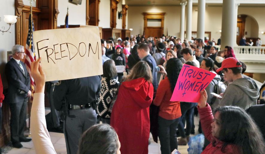 Protesters opposed to a proposed abortion bill fill the hallway on Monday, March 18, 2019, in Atlanta. A Georgia Senate committee approved a measure that would ban most abortions once a fetal heartbeat can be detected. Republicans in Georgia are joining others in many states moving to enact tough abortion restrictions, even though they're certain to be challenged in court, in hopes that recent appointments to the U.S. Supreme Court will find them constitutional. (Bob Andres/Atlanta Journal-Constitution via AP)