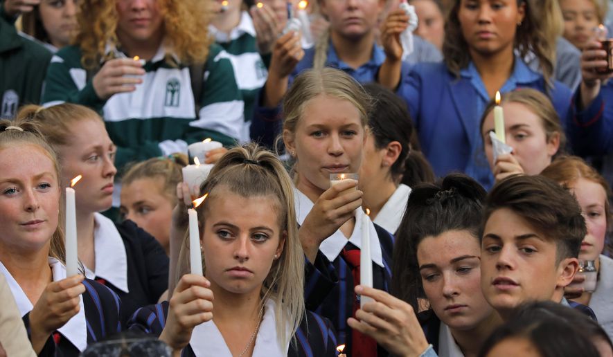 Students raise candles as they gather for a vigil to commemorate victims of Friday's shooting, outside the Al Noor mosque in Christchurch, New Zealand, Monday, March 18, 2019. Three days after Friday's attack, New Zealand's deadliest shooting in modern history, relatives were anxiously waiting for word on when they can bury their loved ones.(AP Photo/Vincent Yu)