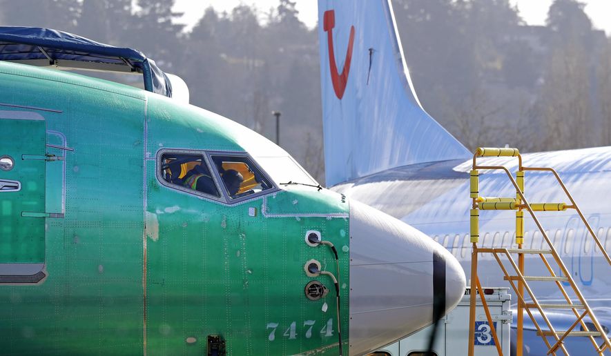 In this March 13, 2019, file photo, people work in the flight deck of a Boeing 737 MAX 8 airplane being built for TUI Group parked next to another MAX 8 also designated for TUI at Boeing Co.&#x27;s Renton Assembly Plant in Renton, Wash. U.S. prosecutors are looking into the development of Boeing&#x27;s 737 Max jets, a person briefed on the matter revealed Monday, the same day French aviation investigators concluded there were &amp;quot;clear similarities&amp;quot; in the crash of an Ethiopian Airlines Max 8 last week and a Lion Air jet in October. (AP Photo/Ted S. Warren, file)