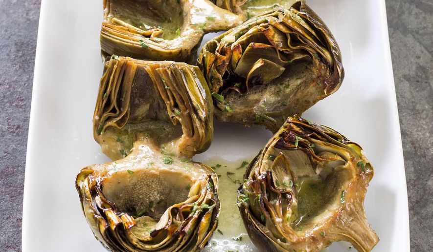 This undated photo provided by America's Test Kitchen in March 2019 shows Roasted Artichokes With Vinaigrette in Brookline, Mass. This recipe appears in the cookbook "Nutritious Delicious." (Daniel J. van Ackere/America's Test Kitchen via AP)