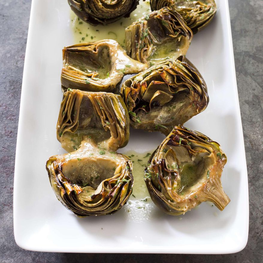 This undated photo provided by America's Test Kitchen in March 2019 shows Roasted Artichokes With Vinaigrette in Brookline, Mass. This recipe appears in the cookbook "Nutritious Delicious." (Daniel J. van Ackere/America's Test Kitchen via AP)