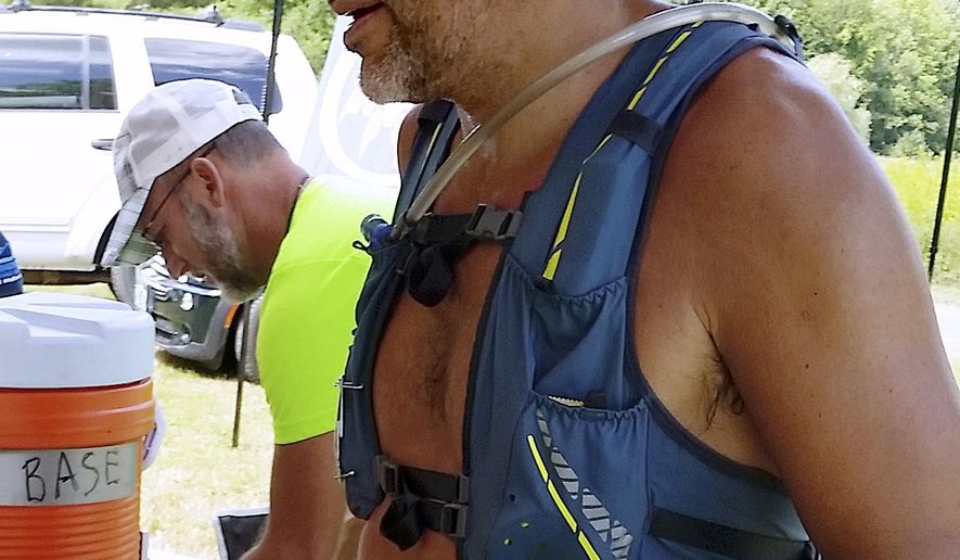 This July 21, 2018 photo provided by Bob Dunfey shows James Eckerd at a road race aid station along the race route in Woodstock, Vt. Officials said Eckert and his wife, Lizette Eckert, were found with gunshot wounds Friday morning, March 15, 2019, inside a home in Alton, N.H. She was pronounced dead at the scene, and he died Friday night. An 11-year-boy was arrested in the case. (Bob Dunfey via AP)