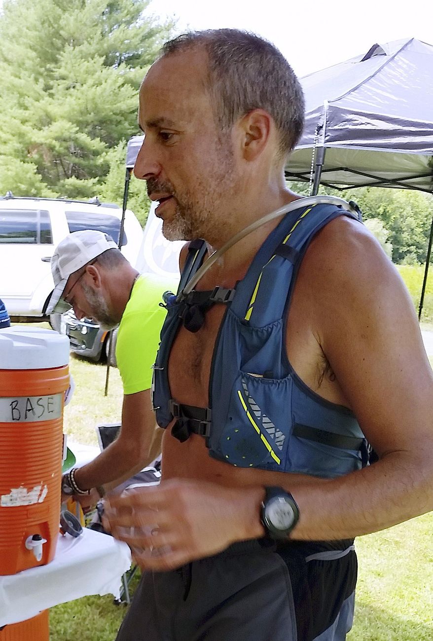 This July 21, 2018 photo provided by Bob Dunfey shows James Eckerd at a road race aid station along the race route in Woodstock, Vt. Officials said Eckert and his wife, Lizette Eckert, were found with gunshot wounds Friday morning, March 15, 2019, inside a home in Alton, N.H. She was pronounced dead at the scene, and he died Friday night. An 11-year-boy was arrested in the case. (Bob Dunfey via AP)