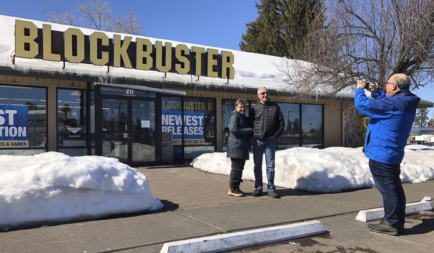 Debby Saltzman, of Bend, Ore., poses for a photo on Monday, March 11, 2019, in front of the last Blockbuster store on the planet with her twin brother, Michael Trovato. Trovato was visiting from Melbourne, Australia, where he lives. Taking the photo is Saltzman&#x27;s husband, Jeremy Saltzman. When a Blockbuster in Perth, Australia, shuts its doors for the last time on March 31, the store in Bend, Ore., will be the only one left on Earth, and most likely in the universe. (AP Photo/Gillian Flaccus)