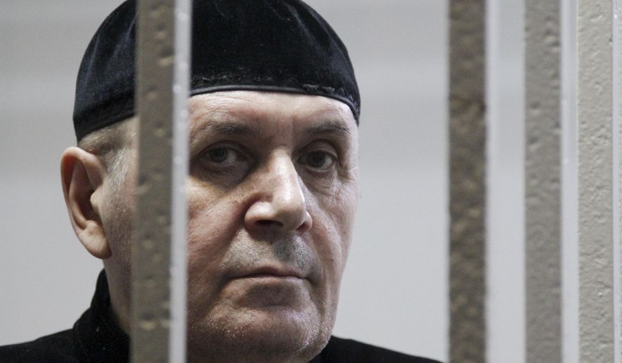 Oyub Titiev, the head of a Chechnya branch of the prominent human rights group Memorial, stands behind bars in court before a hearing in Shali, Russia, Monday, March 18, 2019. Oyub Titiyev was detained in January 2018 and charged with drug possession in what has been largely perceived as a vendetta against this rare critic of the Chechen government. The court is due to issue its verdict Monday. (AP Photo/Musa Sadulayev)