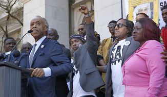 Stevante Clark, center, the brother of police shooting victim Stephon Clark, raises his fist as The Rev. Al Sharpton calls for California to change how it responds to police killings of civilians during a news conference at the Capitol on Monday, March 18, 2019, in Sacramento, Calif. Monday marks a year since two Sacramento police officers killed Clark, 22, as they responded to vandalism reports. Looking on are Stephon Clark&#39;s mother, SeQuette Clark, right, and uncle Curtis Gordon, second from right. (AP Photo/Rich Pedroncelli)