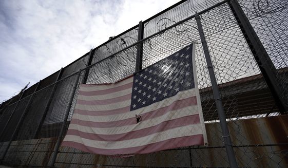 In this Monday, Jan. 21, 2019, photo, a U.S. flag hangs on a border barrier in El Paso, Texas. (AP Photo/Eric Gay) **FILE**