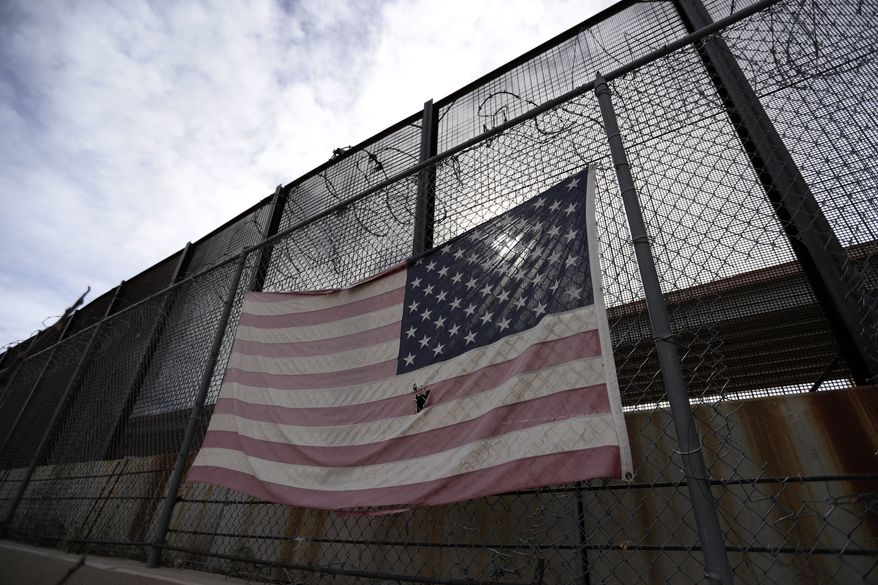 In this Monday, Jan. 21, 2019, photo, a U.S. flag hangs on a border barrier in El Paso, Texas. (AP Photo/Eric Gay) **FILE**