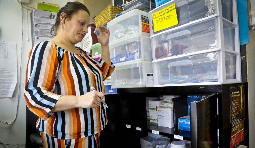 In this Friday, March 15, 2019, photo, Laura Levine prepares to dispense drugs at Vocal NY, an organization that works with addicts, where she is the health educator and coordinator for the opioid reversal drug Narcan, in the Brooklyn borough of New York. New York state is considering providing medication-assisted treatment to all prison and jail inmates struggling with opioid addiction. (AP Photo/Bebeto Matthews)