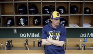 FILE - In this Saturday, March 2, 2019, file photo, Milwaukee Brewers manager Craig Counsell waits in the dugout for the start of a spring baseball game against the Chicago Cubs in Mesa, Ariz. The Brewers are well-positioned for more success this year after winning the NL Central and making it to the NL Championship Series last October. (AP Photo/Chris Carlson, File)
