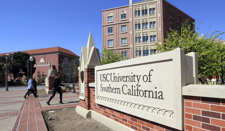 FILE - This Tuesday, March 12, 2019 file photo shows the University Village area of the University of Southern California in Los Angeles. The university says a review of students possibly connected to a college admissions bribery scandal could lead to expulsions. The university said in a statement Monday, March 18, 2019, it has placed holds on the accounts of those students, which prevents them from registering for classes or acquiring transcripts while their cases are under review. (AP Photo/Reed Saxon,File)