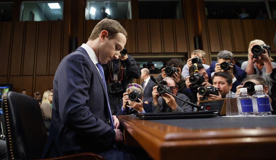 FILE- In this April 10, 2018, file photo Facebook CEO Mark Zuckerberg adjusts his tie as he arrives to testify before a joint hearing of the Commerce and Judiciary Committees on Capitol Hill in Washington. Earlier this month Zuckerberg announced a new “privacy-focused vision” for the company to focus on messaging instead of more public sharing, but he stayed mum on overhauling Facebook’s privacy practices in its core business. (AP Photo/Carolyn Kaster, File)