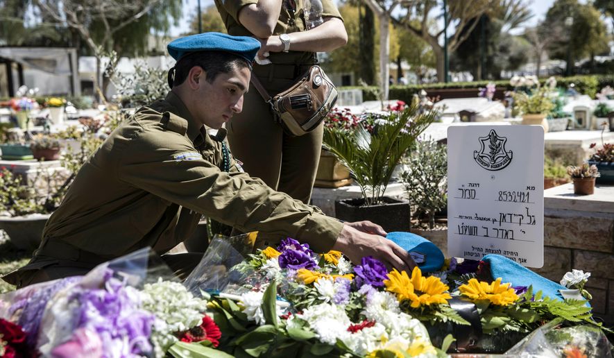 Israeli soldiers and friends of Staff Sgt. Gal Keidan mourn at his grave after the funeral in the city of Beersheba, Monday, March 18, 2019. Keidan was killed by Palestinian assailant in the West Bank Sunday. (AP Photo/Tsafrir Abayov)