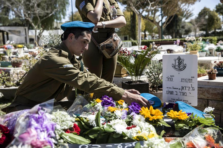 Israeli soldiers and friends of Staff Sgt. Gal Keidan mourn at his grave after the funeral in the city of Beersheba, Monday, March 18, 2019. Keidan was killed by Palestinian assailant in the West Bank Sunday. (AP Photo/Tsafrir Abayov)