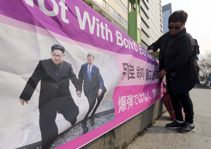 A woman displays a banner showing a photo of North Korean leader Kim Jong Un and South Korean President Moon Jae-in, right, to wish for peace on the Korean Peninsula, in Seoul, South Korea, Tuesday, March 19, 2019. International journalists&#39; organizations have expressed concern over South Korea&#39;s press freedoms after the country&#39;s ruling party singled out a Bloomberg reporter over what it claimed was a &amp;quot;borderline treacherous&amp;quot; article insulting Moon, resulting in threats to the reporter&#39;s safety. (AP Photo/Ahn Young-joon)