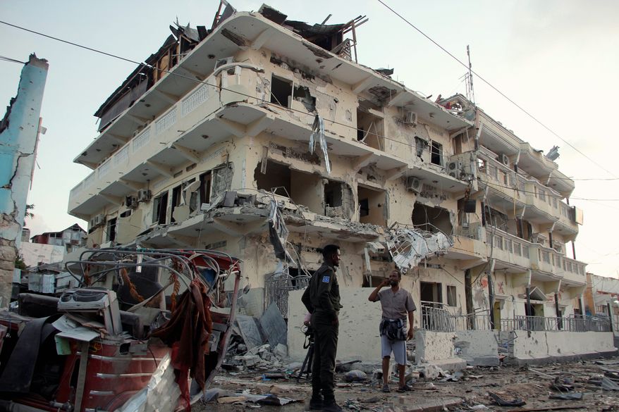 Somali soldiers stand guard at a destroyed building in Mogadishu, Somalia, Friday, March 1, 2019. Police say a nearly day-long siege in the heart of Somalia's capital has ended with all of the al-Shabab extremist attackers killed. More than 20 are dead with the number expected to climb as hospitals report more than 50 wounded, many in critical condition. The attack comes after a flurry of U.S. airstrikes against the al-Qaida-linked extremist group, the deadliest Islamic extremist organization in Africa. (AP Photo/Farah Abdi Warsameh)