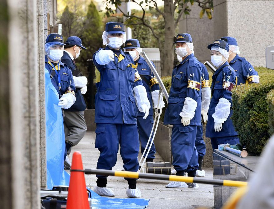 Police investigators inspect the site that a woman was attacked at a court in Tokyo, Wednesday, March 20, 2019. Police have arrested an American man in an alleged fatal stabbing of his Japanese wife at a Tokyo court where they were reportedly settling a divorce. (Kyodo News via AP)