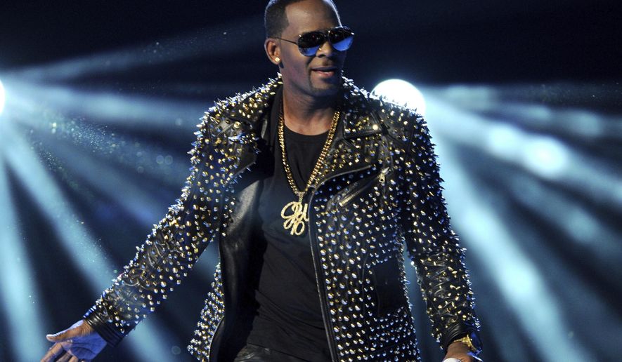 FILE - In this June 30, 2013 file photo, R. Kelly performs at the BET Awards in Los Angeles. Kelly has asked the Chicago judge to let him travel overseas for concerts in Dubai, saying he’s been unable to get work anywhere in the U.S. since his arrest on charges he sexually abused three minor girls and an adult woman. The request in a Wednesday filing says the R&B star will perform at up to five concerts in the oil-rich nation in the Middle East. A judge ordered Kelly to surrender his passport after his arrest last month on 10 counts of aggravated sexual abuse. (Photo by Frank Micelotta/Invision/AP, File)