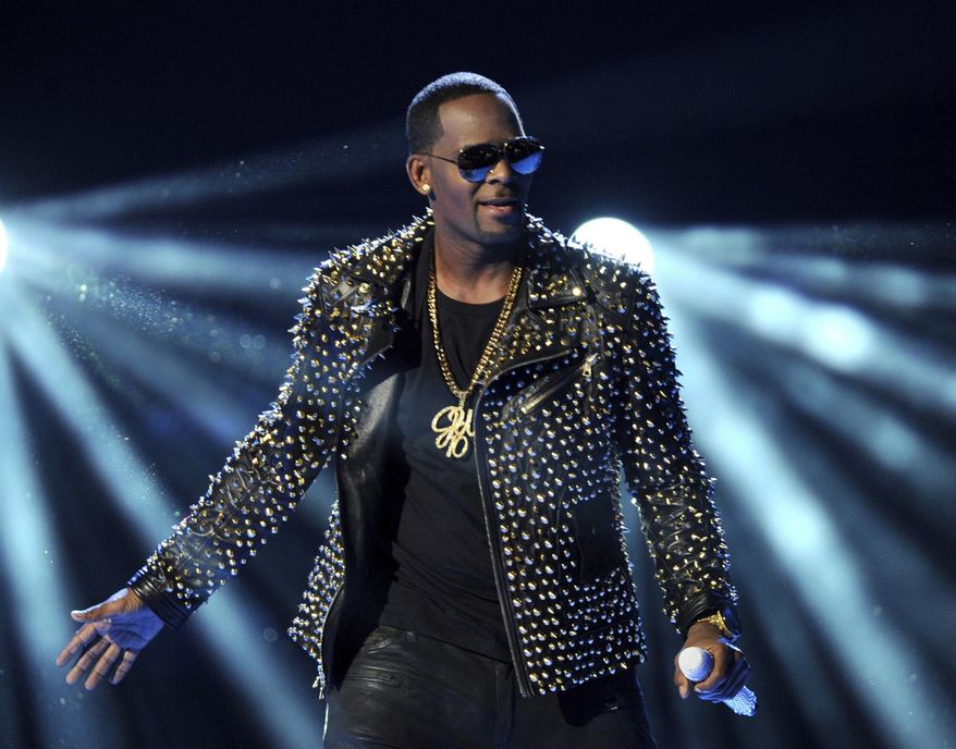 FILE - In this June 30, 2013 file photo, R. Kelly performs at the BET Awards in Los Angeles. Kelly has asked the Chicago judge to let him travel overseas for concerts in Dubai, saying he’s been unable to get work anywhere in the U.S. since his arrest on charges he sexually abused three minor girls and an adult woman. The request in a Wednesday filing says the R&B star will perform at up to five concerts in the oil-rich nation in the Middle East. A judge ordered Kelly to surrender his passport after his arrest last month on 10 counts of aggravated sexual abuse. (Photo by Frank Micelotta/Invision/AP, File)