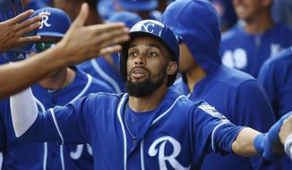 Kansas City Royals&#39; Billy Hamilton celebrates his run scored against the Cincinnati Reds with teammates in the dugout during the first inning of a spring training baseball game Friday, March 8, 2019, in Surprise, Ariz. (AP Photo/Ross D. Franklin)