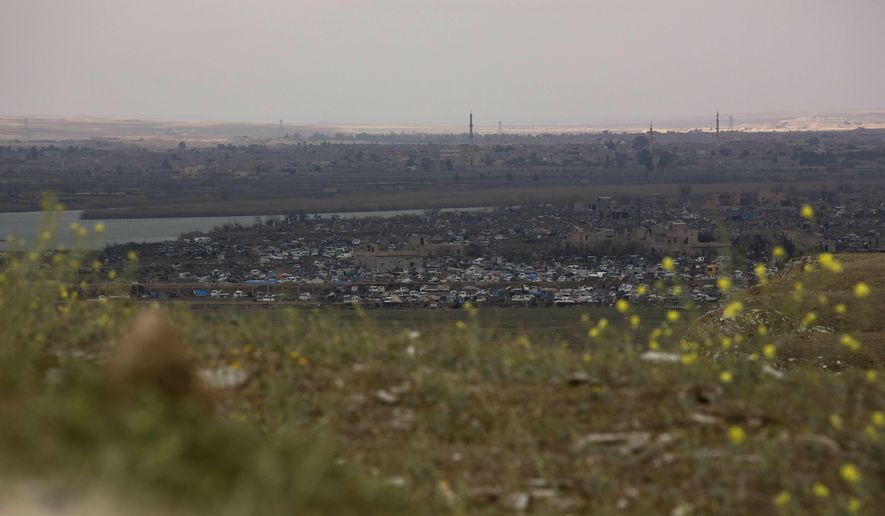 In this Sunday, March 17, 2019, photo, the Islamic State group's last pocket of territory in Baghouz, Syria, as seen from a distance. On Tuesday, a spokesman for U.S.-backed forces fighting IS in Syria says his fighters are in control of an encampment in the village of Baghouz where IS militants have been besieged for months. (AP Photo/Maya Alleruzzo)