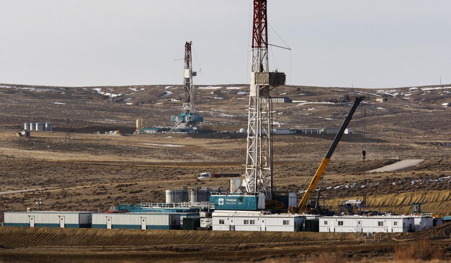 FILE- In this March 5, 2013, file photo, Trinidad Drilling rigs are seen off of Way Highway 59 outside of Douglas, Wyo. A judge has blocked oil and gas drilling on almost 500 square miles in Wyoming and says the government must consider cumulative climate change impacts of leasing public lands across the U.S. for energy development. The order marks the latest in a string of court rulings over the past decade faulting the government's consideration of emissions when issuing energy leases. (Leah Millis/The Casper Star-Tribune via AP, File)