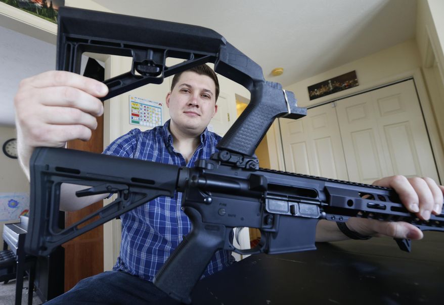 In this March 15, 2019, file photo, Ryan Liskey displays a bump stock on top of his AR-15 at his home in Harrisonburg, Va. The ban on bump stocks is just a few days away and owners of the devices like Liskey are trying to figure out what to do. (AP Photo/Steve Helber)