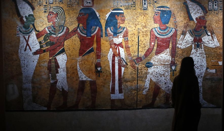 A visitor walks in 'Tutankhamun, the treasure of the Pharaoh', an exhibition in partnership with the Grand Egyptian Museum at the Grande Halle of La Villette in Paris, France, Thursday, March 21, 2019. This exhibition, which runs from 23 March to 15 September 2019. will reveal 150 fascinating original objects found in 1922 in the tomb of the most famous Pharaoh. (AP Photo/Francois Mori)