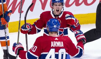 Montreal Canadiens&#x27; Jordan Weal, top, congratulates Joel Armia following his goal against the New York Islanders during the first period of an NHL hockey game Thursday, March 21, 2019, in Montreal. (Paul Chiasson/The Canadian Press via AP)