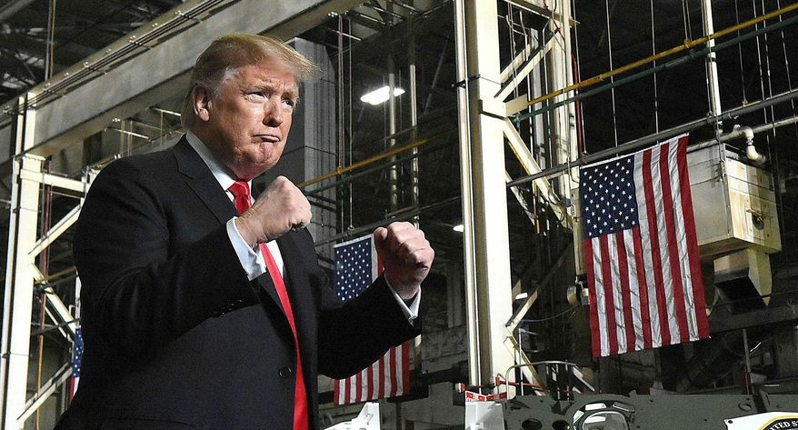 President Donald Trump make two fists while making his entrance to the Joint Systems Manufacturing Center to address employee's. (Craig J. Orosz /The Lima News via AP)