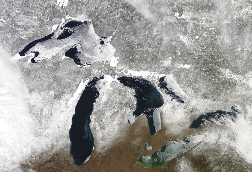 In this March 12, 2019 satellite photo provided by NOAA, shows the Great Lakes in various degrees of snow and ice. A scientific report says the Great Lakes region is warming faster than the rest of the U.S., which likely will bring more flooding and other extreme weather events such as heat waves and drought. The warming climate also could mean less overall snowfall even as lake-effect snowstorms get bigger. The report by researchers from universities primarily from the Midwest says agriculture could be hit especially hard, with later spring planting and summer dry spells. (NOAA via AP)