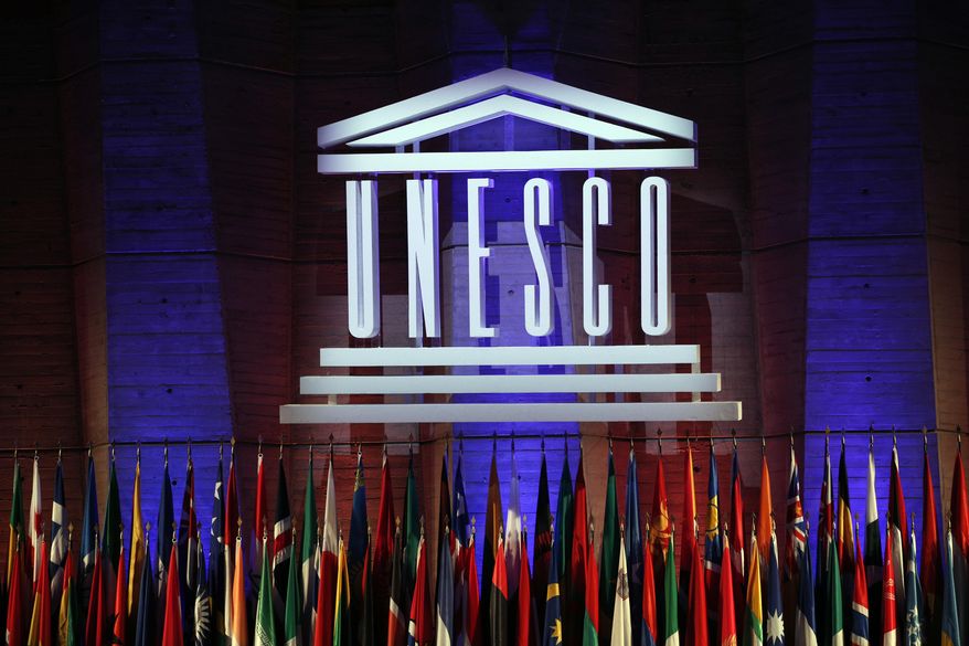 FILE - In this Nov.4, 2017 file photo, the logo of the United Nations Educational, Scientific and Cultural Organisation (UNESCO) is seen during the 39th session of the General Conference at the UNESCO headquarters in Paris. The U.N.'s cultural agency considers the possible removal of the recognition of a Belgium carnival as intangible cultural heritage following accusations of anti-Semitism during a parade. (AP Photo/Christophe Ena, File)