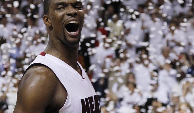 FILE - In this June 21, 2012, file photo, Miami Heat power forward Chris Bosh reacts after Game 5 of the NBA finals basketball series against the Oklahoma City Thunder, in Miami. Bosh, whose career was cut short in 2016 by blood clots, will have his No. 1 jersey retired by the Miami Heat on Tuesday night, March 26, 2019. Bosh, an 11-time All-Star and two-time champion with the Heat, will be the fourth former Miami player to have a jersey retired. (AP Photo/Lynne Sladky, File)