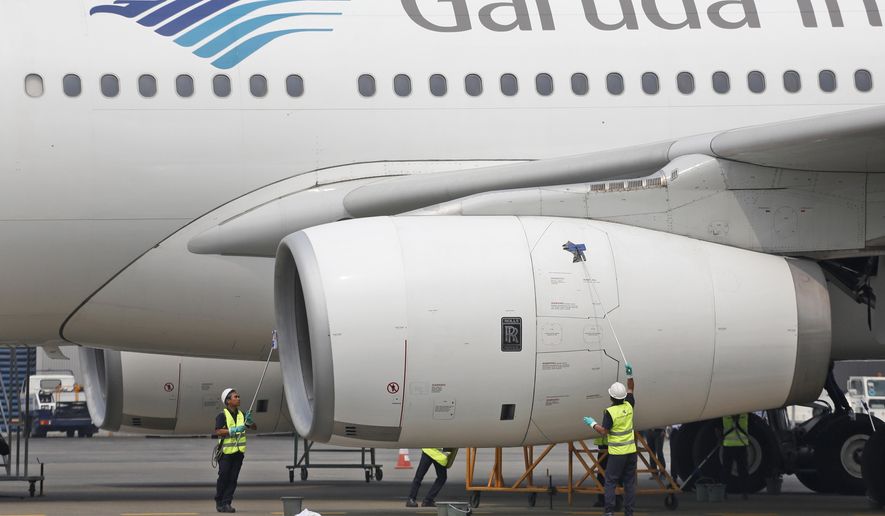 FILE - In this Sept. 28, 2015, file photo, workers clean a jetliner at GMF AeroAsia facility at Soekarno-Hatta International Airport in Jakarta, Indonesia. Indonesia's flag carrier is seeking the cancellation of a multibillion-dollar order for 49 Boeing 737 Max 8 jets, citing a loss of confidence in the model following two crashes in the space of a few months. (AP Photo/Dita Alangkara, File)