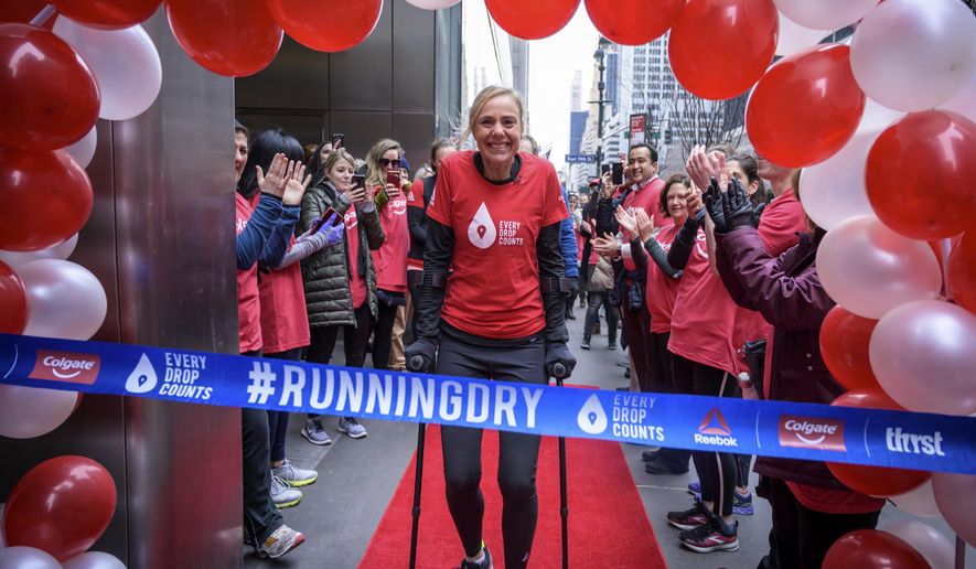 This Feb. 11, 2019, photo provided by Colgate, shows ultra-marathoner and water activist Mina Guli, aided by canes, approaching a ceremonial finish line in New York. Gulia came close to running 100 marathons in 100 days over sever continents, all in an effort to raise awareness about global water shortages and how to prevent them. (Kelvin Trautman/Colgate via AP)
