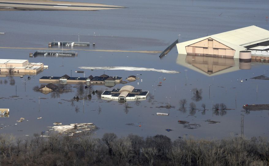 This March 17, 2019 photo released by the U.S. Air Force shows an aerial view of Offutt Air Force Base and the surrounding areas affected by flood waters in Neb. Surging unexpectedly strong and up to 7 feet high, the Missouri River floodwaters that poured on to much the Nebraska air base that houses the U.S. Strategic Command overwhelmed the frantic sandbagging by troops and their scramble to save sensitive equipment, munitions and aircraft. (Tech. Sgt. Rachelle Blake/The U.S. Air Force via AP)