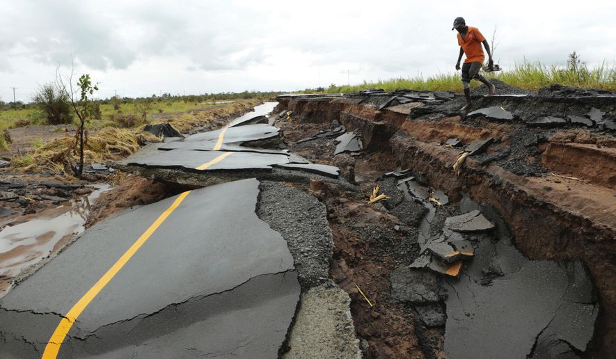 A man passes through a section of the road damaged by Cyclone Idai in Nhamatanda about 50 kilometres from Beira, in Mozambique, Friday March, 22, 2019. As flood waters began to recede in parts of Mozambique on Friday, fears rose that the death toll could soar as bodies are revealed. (AP Photo/Tsvangirayi Mukwazhi)