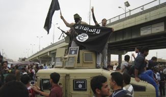In this Sunday, March 30, 2014, file photo, Islamic State group militants hold up their flag as they patrol in a commandeered Iraqi military vehicle in Fallujah, 40 miles (65 kilometers) west of Baghdad, Iraq. (AP Photo) ** FILE **