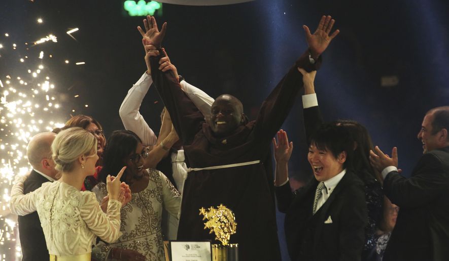 Kenyan teacher Peter Tabichi, center, reacts after winning the $1 million Global Teacher Prize in Dubai, United Arab Emirates, Sunday, March 24, 2019. Tabichi is a science teacher who gives away 80 percent of his income to the poor in the remote Kenyan village of Pwani. (AP Photo/Jon Gambrell)