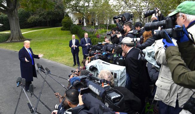 President Trump faces a wall of reporters and photographers during a brief question and answer session on the White House lawn. (Associated Press)