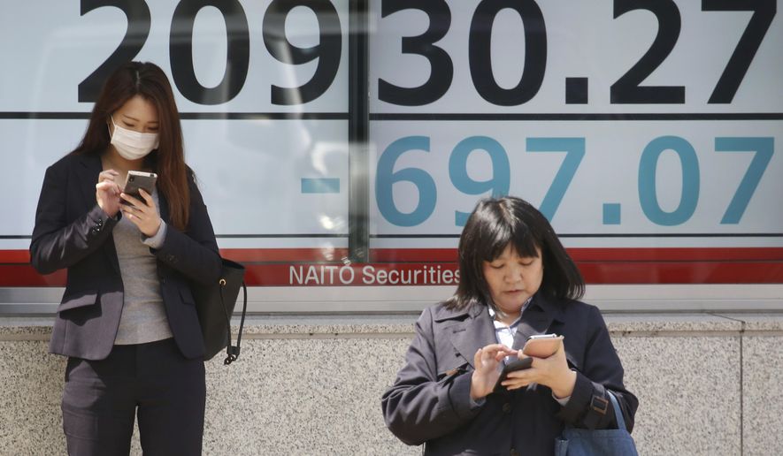 People stand in front of an electronic stock board of a securities firm in Tokyo, Monday, March 25, 2019. Shares were sharply lower in Asia on Monday after Wall Street ended last week with a broad retreat.(AP Photo/Koji Sasahara)