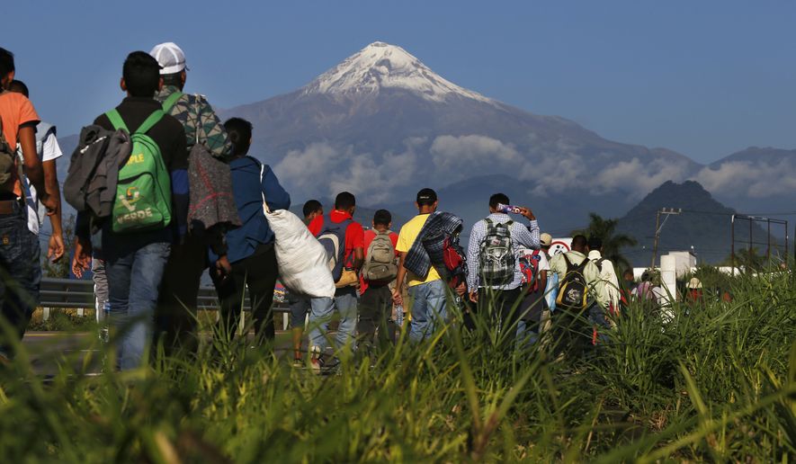 Central American migrants begin their morning trek as part of a thousands-strong caravan hoping to reach the U.S. border, as they face the Pico de Orizaba volcano upon departure from Cordoba, Veracruz state, Mexico, Monday, Nov. 5, 2018. A big group of Central Americans pushed on toward Mexico City from a coastal state Monday, planning to exit a part of the country that has long been treacherous for migrants seeking to get to the United States. (AP Photo/Marco Ugarte)