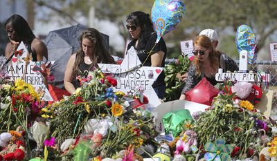 FILE - In this Feb. 25, 2018 file photo, mourners bring flowers as they pay tribute at a memorial for the victims of the shooting at Marjory Stoneman Douglas High School, in Parkland, Fla. The community of Parkland, Florida, is focusing on suicide prevention programs after two survivors of the Florida high school massacre there killed themselves this month. Parkland Mayor Christine Hunschofsky said Monday, March 25, 2019, that officials are publicizing the available counseling services after a second Marjory Stoneman Douglas High School student apparently killed himself over the weekend.  (David Santiago/Miami Herald via AP, File)