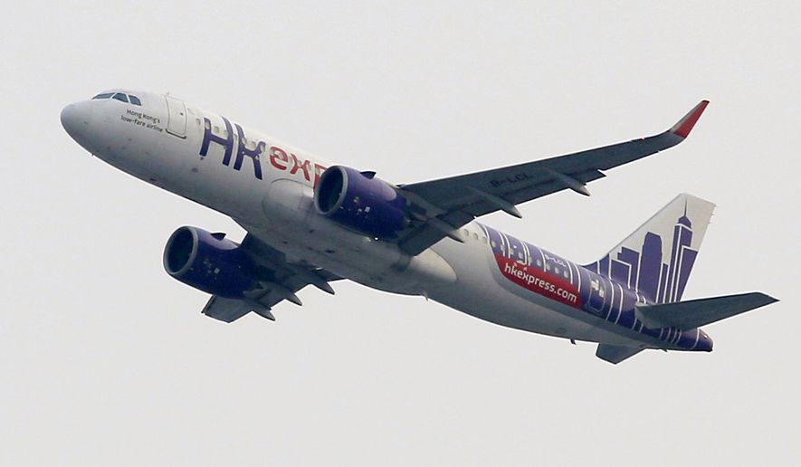 In this March 26, 2019 photo, a Hong Kong Express Airways passenger aircraft takes off from at the Hong Kong International Airport.  Cathay Pacific Airways is acquiring Hong Kong-based budget airline HK Express. Cathay said Wednesday, March 27, 2019, it will pay 4.93 billion Hong Kong dollars ($628 million) for HK Express. It said the acquisition will retain its identity as a separate brand and be operated as a low-cost carrier. (AP Photo/Kin Cheung)