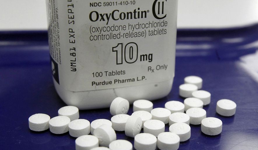 This Feb. 19, 2013, file photo shows OxyContin pills arranged for a photo at a pharmacy in Montpelier, Vt. Oklahoma's attorney general will announce a settlement Tuesday, March 26, 2019, with Purdue Pharma, one of the drug manufacturers named in a state lawsuit that accuses them of fueling the opioid epidemic. (AP Photo/Toby Talbot, File)