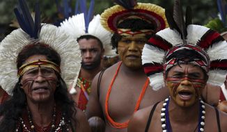 Pataxo men take part in a protest against the proposal by Brazil&#39;s president to transfer the responsibility of health services from the federal level to municipal governments, outside the Ministry of Health, in Brasilia, Tuesday, March 26, 2019. (AP Photo/Eraldo Peres)