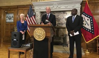 FILE - In this Sept. 12, 2018, file photo, Arkansas Gov. Asa Hutchinson, center, talks at a news conference at the State Capitol in Little Rock, Ark., about the state&#39;s work requirement for its expanded Medicaid program. Federal judge James Boasberg is blocking Medicaid work requirements in Arkansas and Kentucky, dealing a blow to the Trump administration’s efforts to push the poor toward self-sufficiency. Boasberg issued two decisions Wednesday, March 27, finding that Medicaid work requirements for low-income people in Arkansas and Kentucky pose numerous obstacles to getting health care that haven’t been adequately addressed by federal and state officials. (AP Photo/Andrew DeMillo, File)