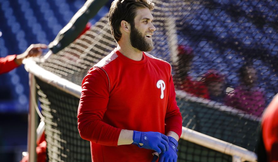 Philadelphia Phillies' Bryce Harper pulls on his gloves for batting practice, Tuesday, March 26, 2019, in Philadelphia. (AP Photo/Matt Rourke)