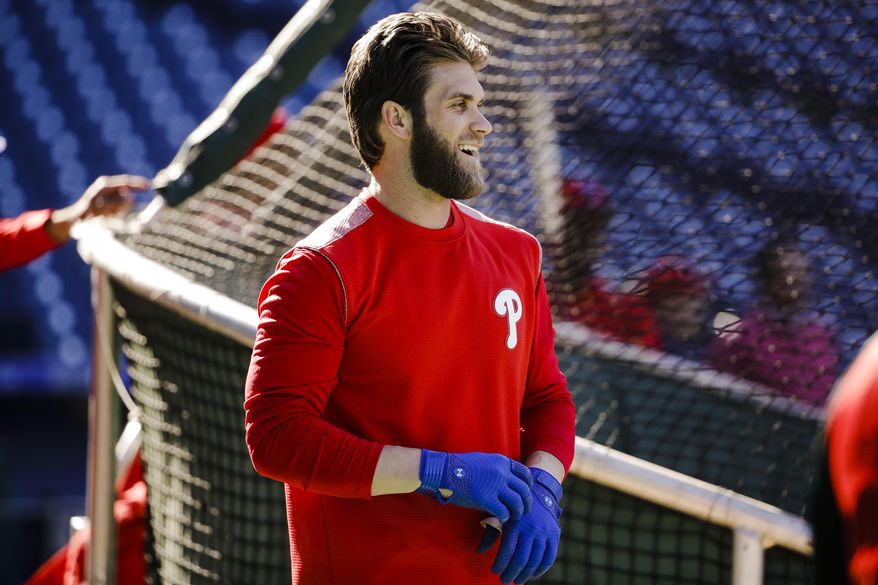 Philadelphia Phillies' Bryce Harper pulls on his gloves for batting practice, Tuesday, March 26, 2019, in Philadelphia. (AP Photo/Matt Rourke)